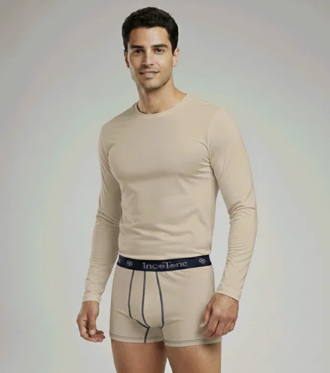 Man wearing a beige long-sleeve shirt and underwear with 'Incotone' branding on a plain background